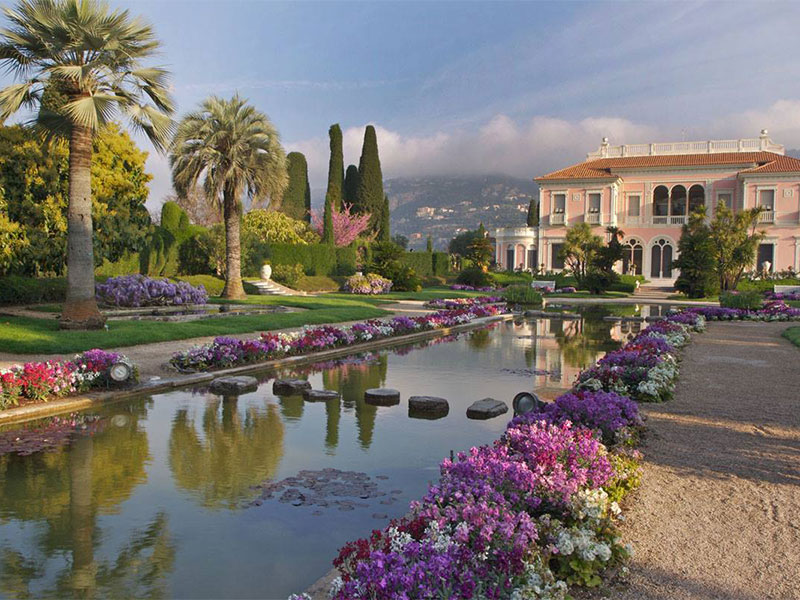 Garden in bloom with pink and purple flowers at Villa Ephrussi