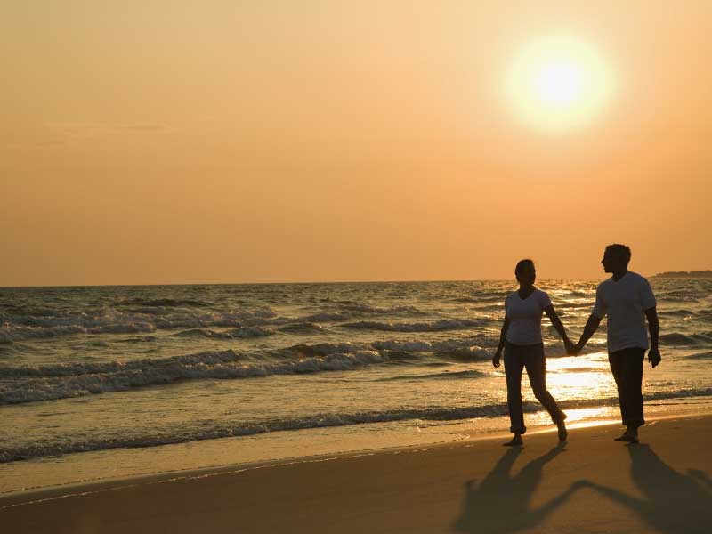 Couple walking on a beach in France holding hands