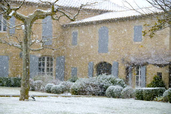 Snow falling in Provence, a pretty house with shutters in the background